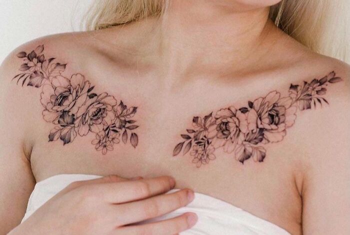 Floral collarbone tattoos on a woman, featuring detailed rose designs.