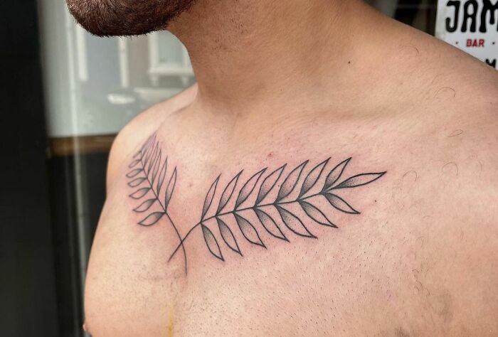 Fern leaf collarbone tattoo on a man's chest.