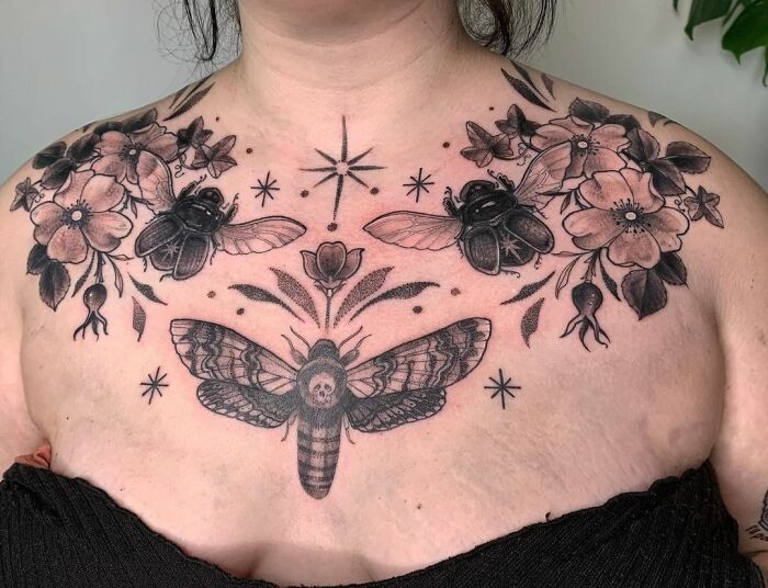 Collarbone tattoo featuring flowers, bees, and a moth design on a person's upper chest.