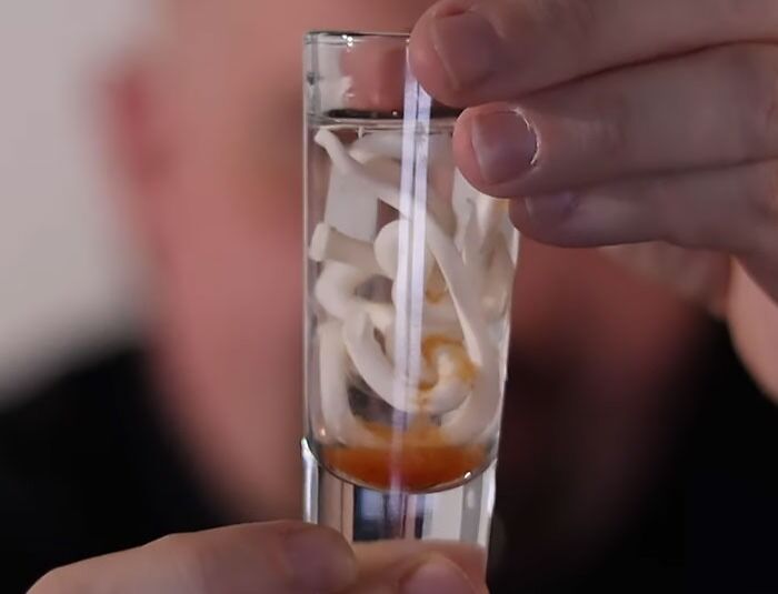 a person holding a shot of bevarage