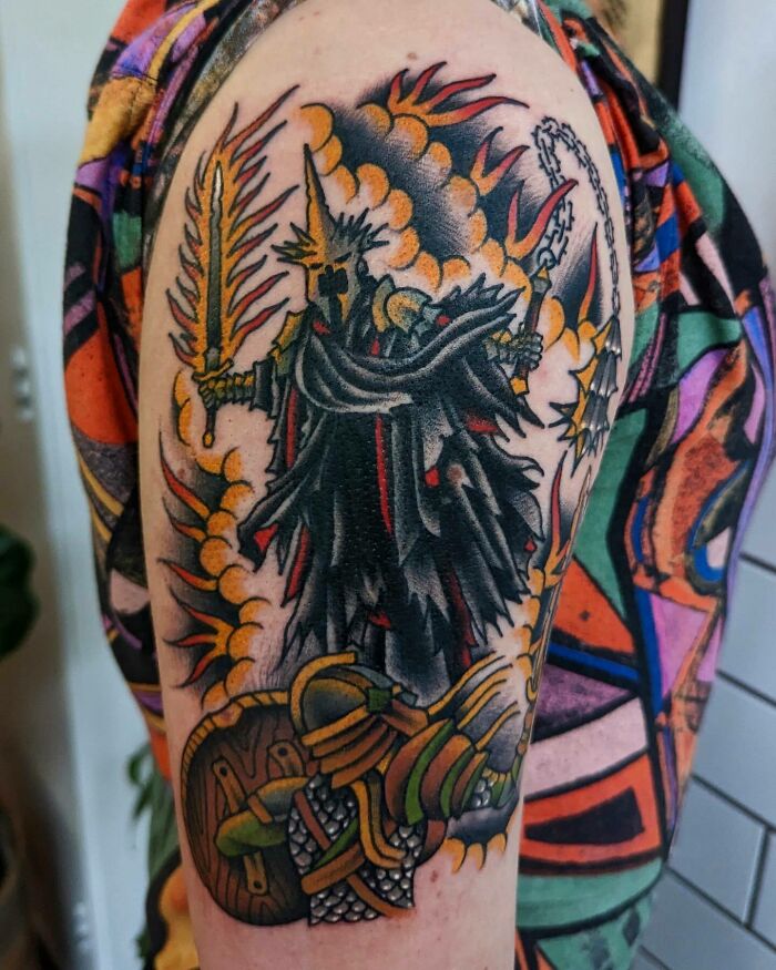 Lord of the Rings tattoo featuring a fearsome armored figure with a flaming sword on a colorful background.