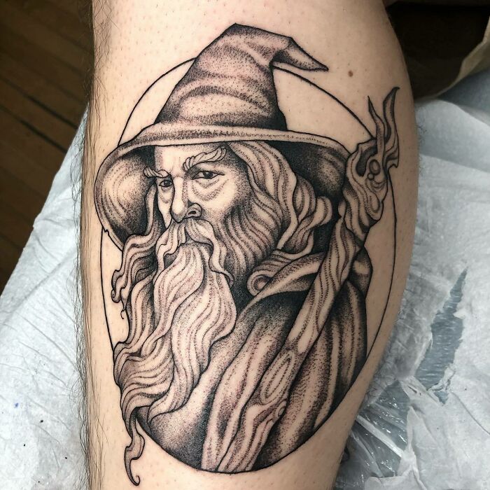 Tattoo of a wizard with a staff, inspired by Lord of the Rings, featuring intricate shading and detail.