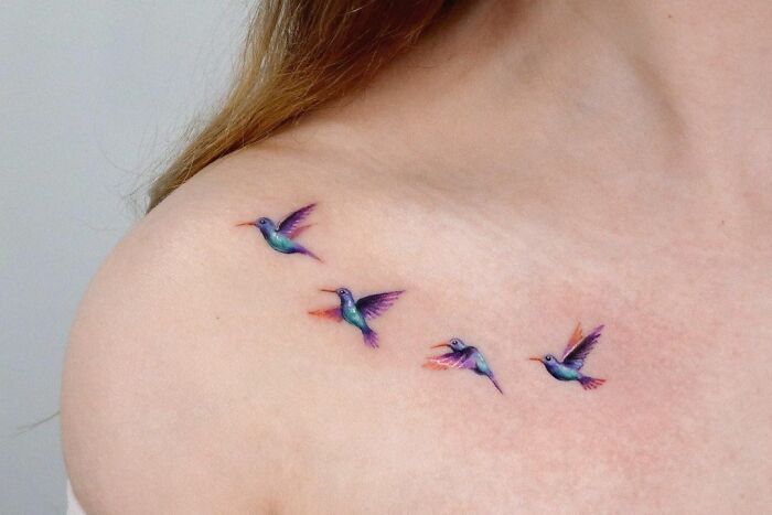 Colorful hummingbird collarbone tattoos on a woman's shoulder, showcasing stunning tattoo design ideas.