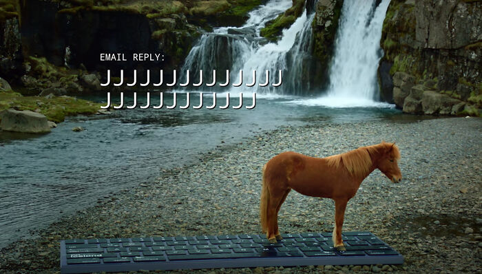 Icelandic horse standing on a giant keyboard by a waterfall, with email reply of repeated "J" letters.