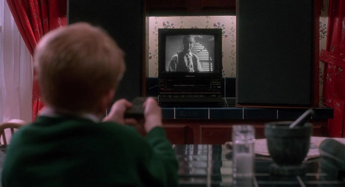 Kevin looking TV set with remote controller in his hands