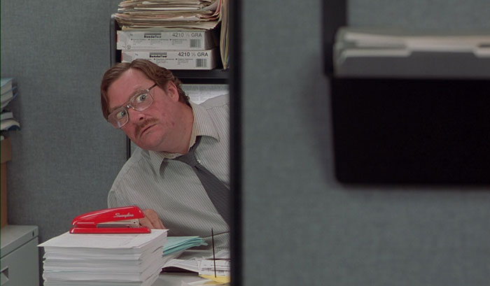 Milton Waddams looking out with fear from his working place