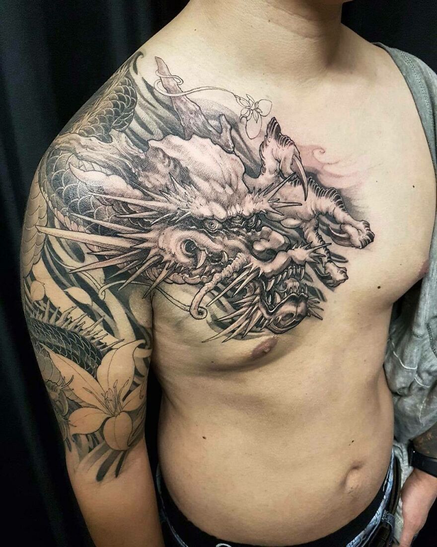 Detailed dragon tattoo design on a person's chest and shoulder.