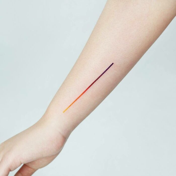 Minimalist wrist tattoo design featuring a gradient line, showcasing a sleek tattoo style.