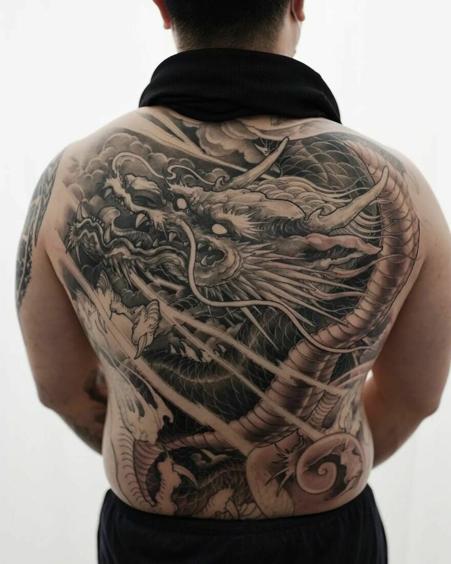 Intricate dragon tattoo covering entire back, showcasing detailed scales and fierce expression.