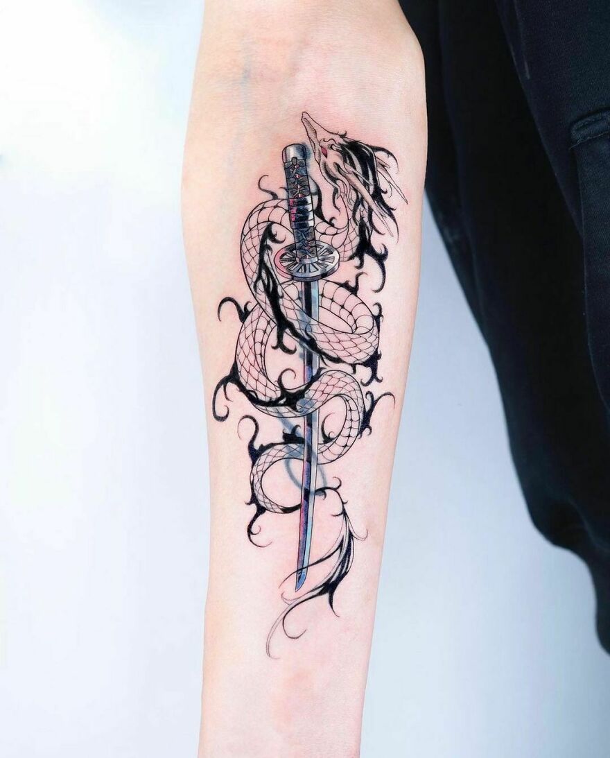 Intricate dragon tattoo design wrapping around a sword on forearm.