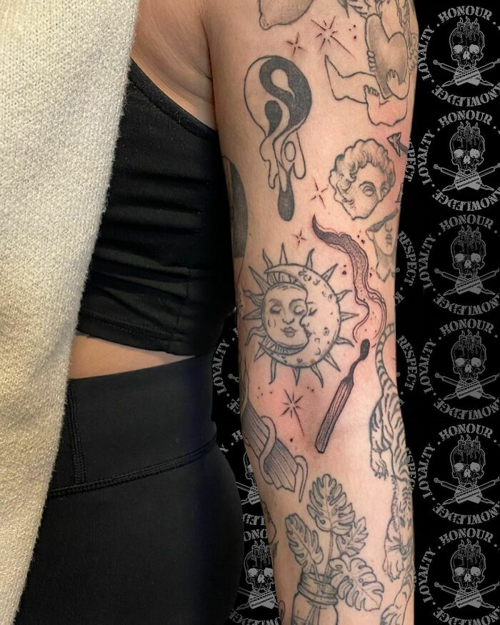 Arm showcasing unique patchwork tattoo design with sun, yin-yang, and celestial elements on a black background.