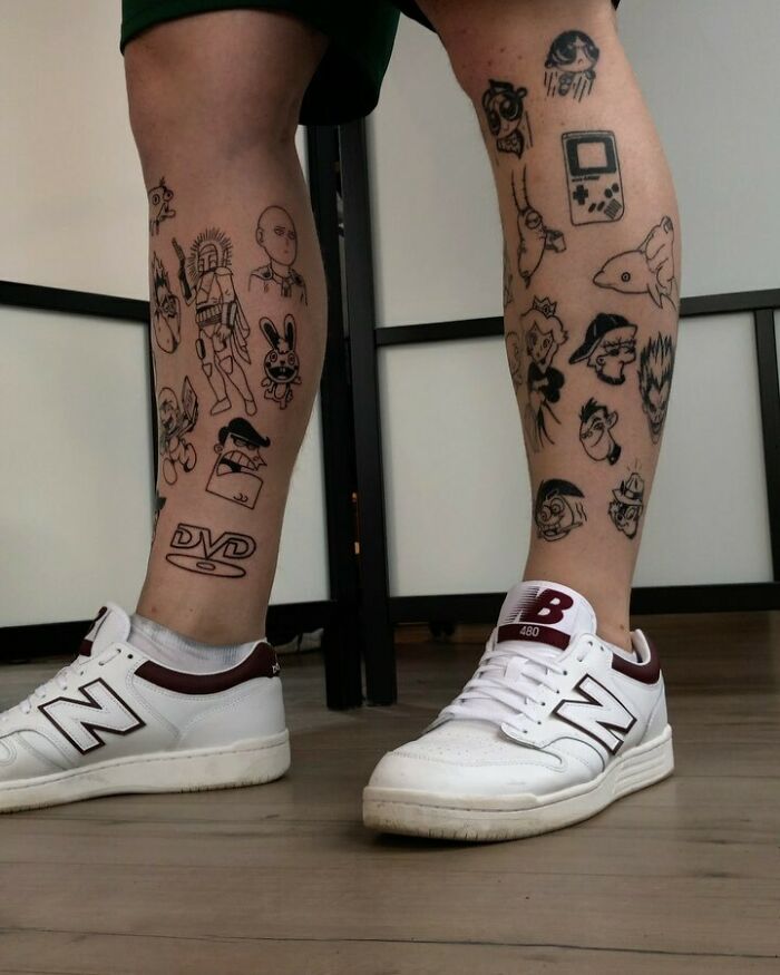 Legs with patchwork tattoos featuring various characters, worn above white New Balance sneakers.