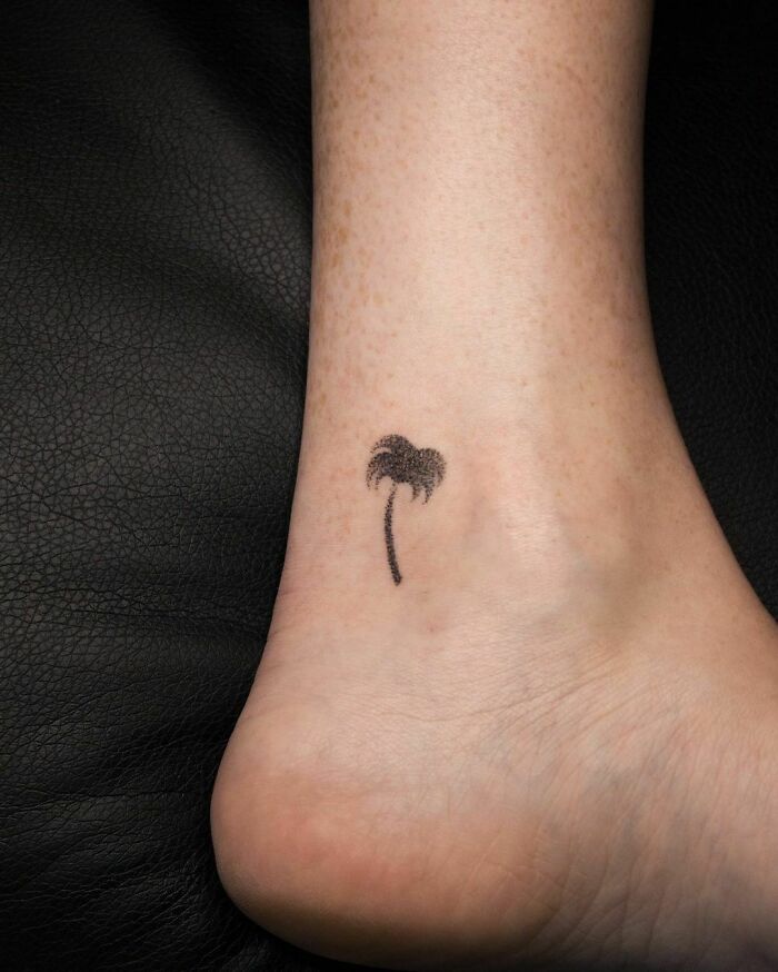 Palm tree ankle tattoo on smooth skin, highlighting tattoo care ideas.
