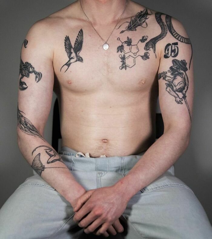 Tattooed torso displaying unique patchwork tattoo designs, featuring a bird, snake, and chemical structure motifs.