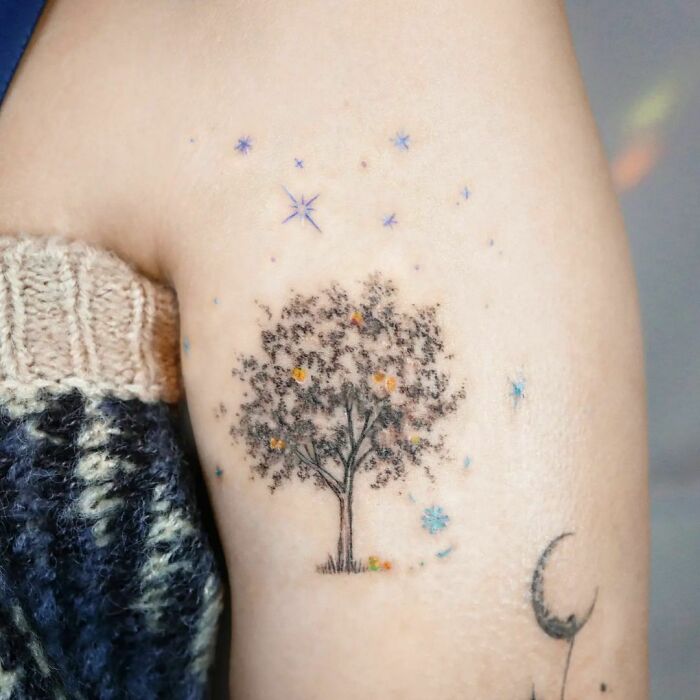 Detailed tree tattoo with starry accents on the arm, celebrating the wonders of nature.