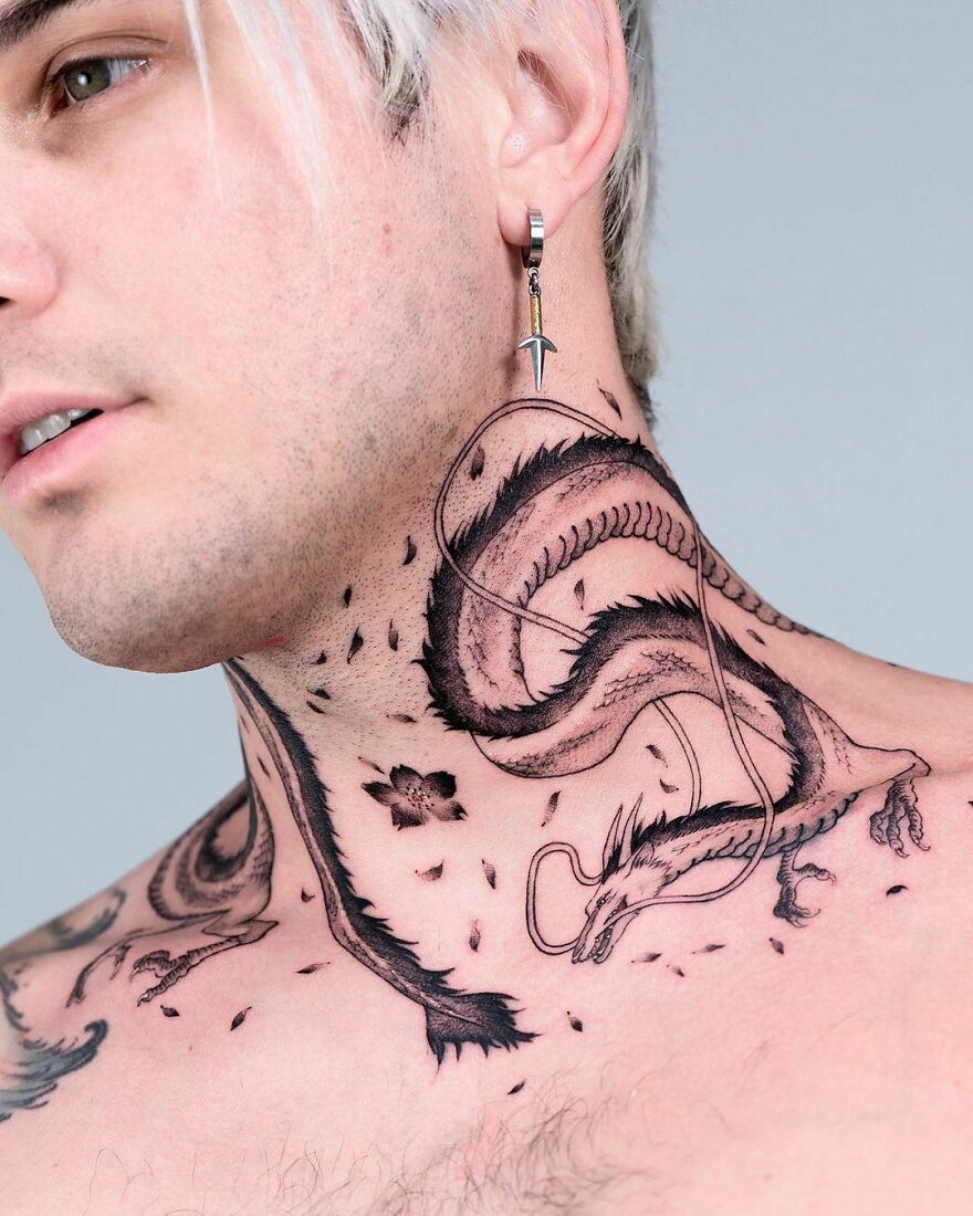 Close-up of a dragon tattoo on a person's neck, featuring intricate details and bold lines.
