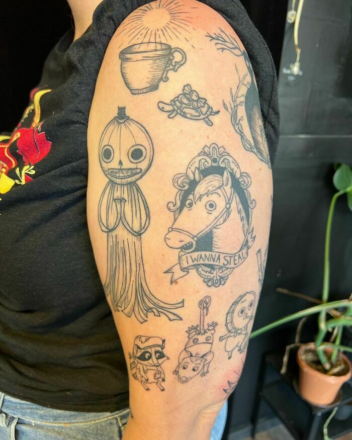 Unique patchwork tattoos on an arm featuring whimsical designs and characters in black ink.