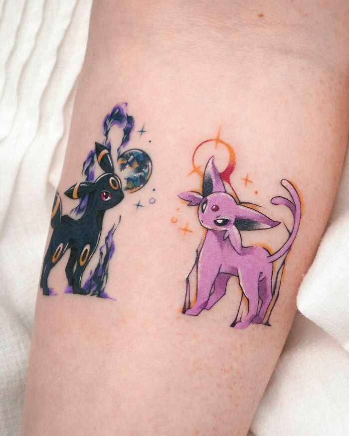 Pop culture tattoos of two cartoon creatures in vibrant colors on skin.
