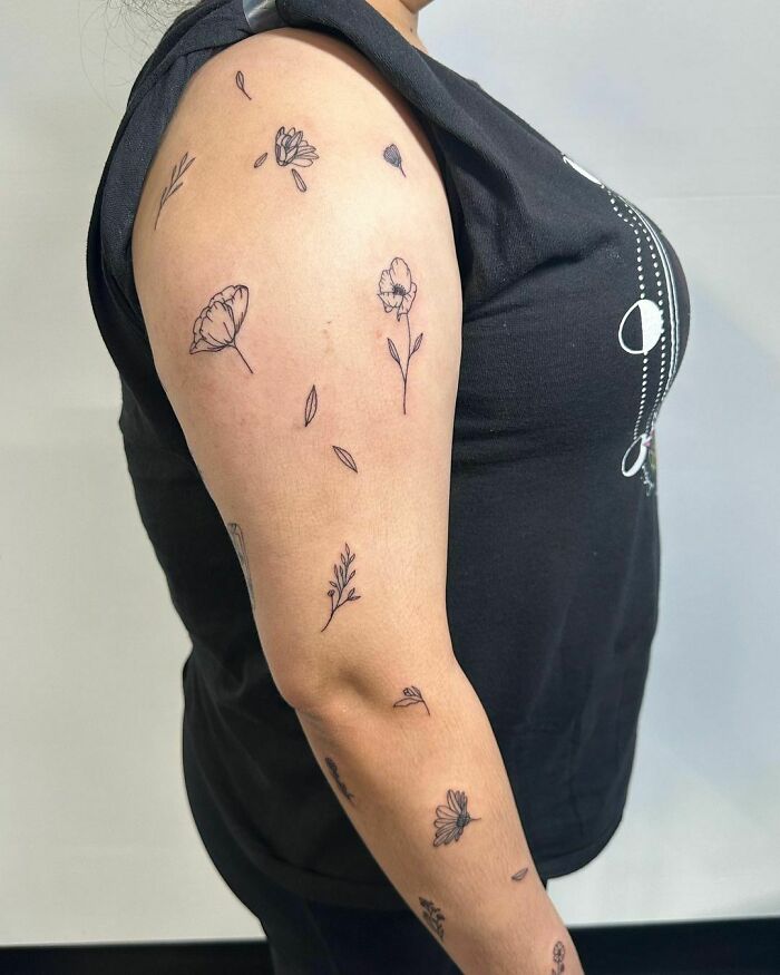 Arm with patchwork tattoo designs featuring flowers and leaves, illustrating unique tattoo ideas.