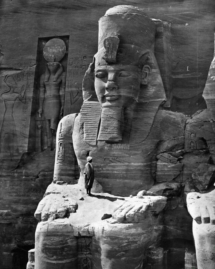 A Photo Of A Man Standing On The Lap Of A Statue Of Ramesses In Egypt, 1856