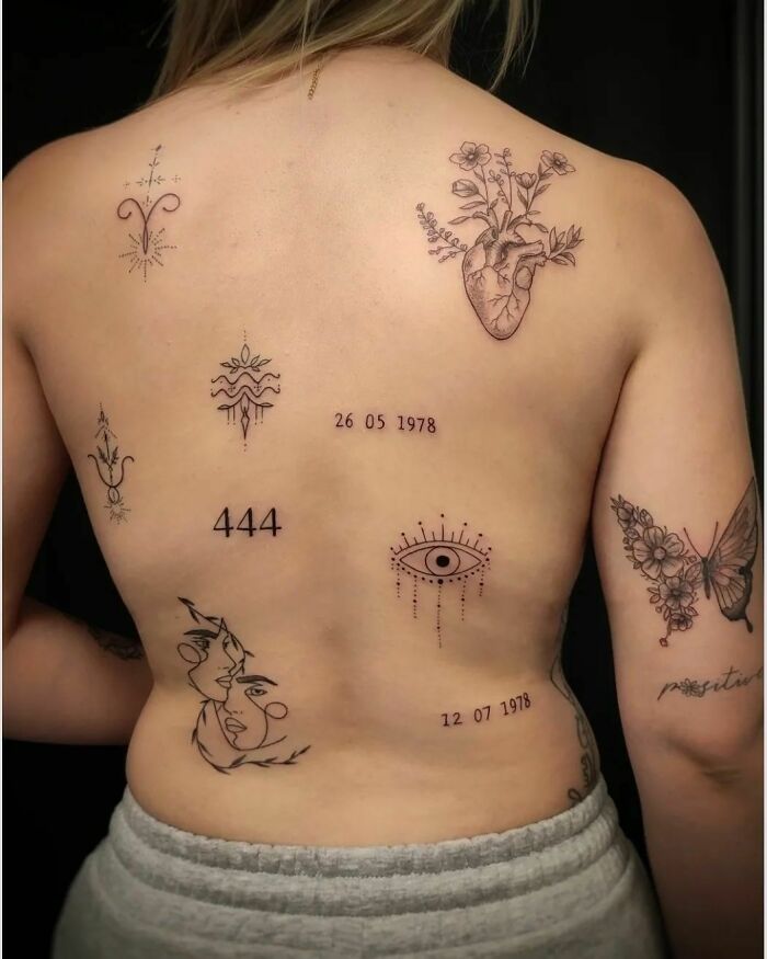 Woman displaying patchwork tattoos including flowers, numbers, and symbols on her back.