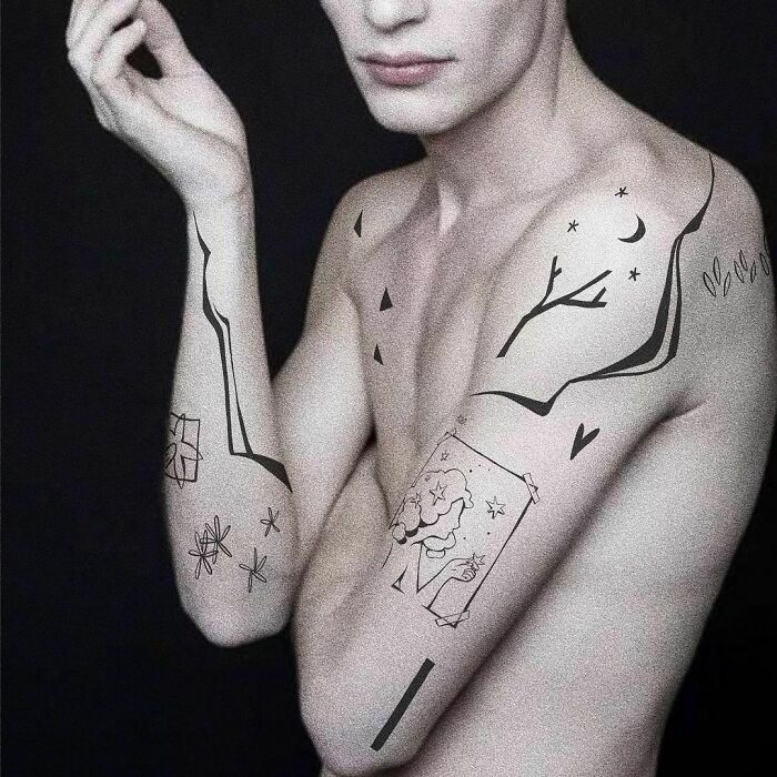 Minimalist patchwork tattoos on a shirtless individual's arms and shoulders, featuring nature and geometric designs.