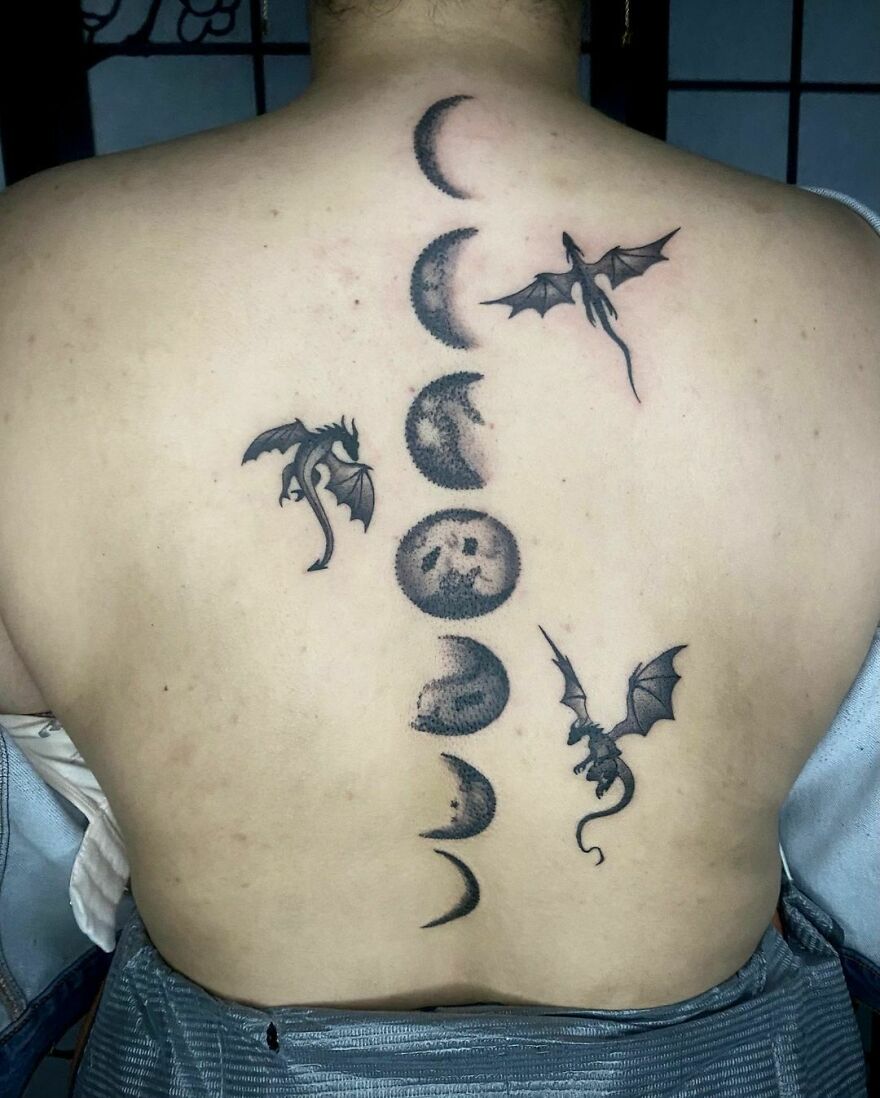 Dragon tattoo with moon phases on back, showcasing unique design elements.