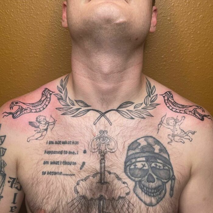 Chest patchwork tattoo with skull, laurel wreath, cherubs, and text art, showcasing modern and eclectic tattoo designs.