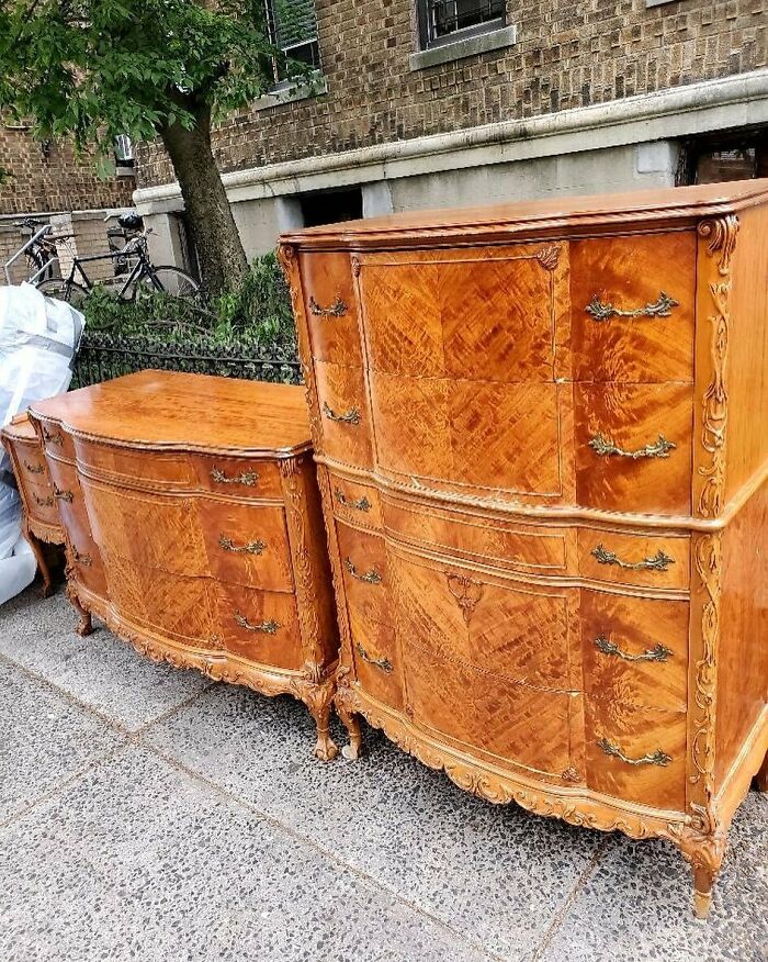 Vintage wooden dressers with intricate carvings placed on a NYC sidewalk, showing real treasures people threw out.