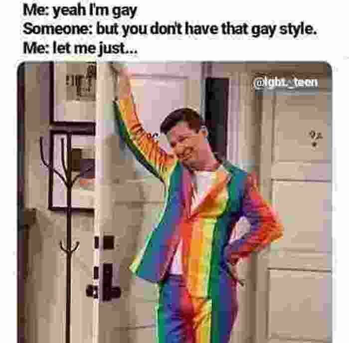 Person in a rainbow suit leaning against a door frame, humorously addressing style stereotypes for Pride Month.