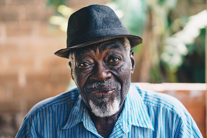 Elderly man wearing a hat and blue shirt, embodying wisdom and character often shared in grandparents advice.