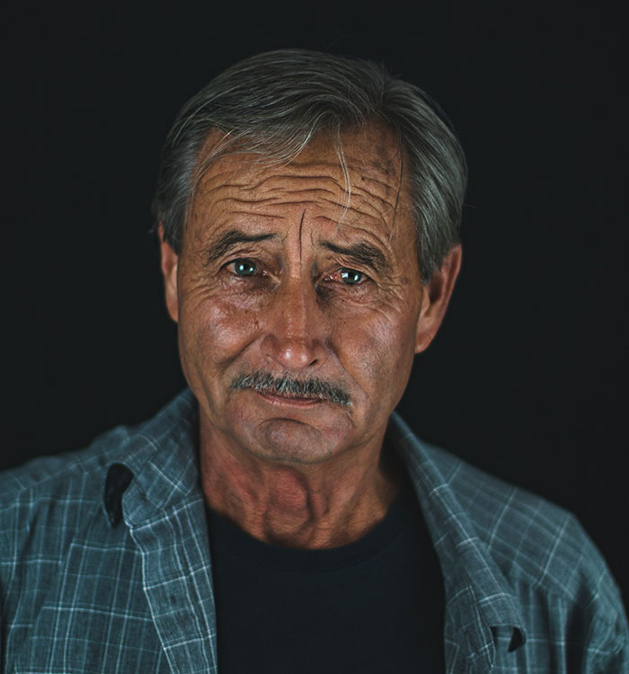 Old man with gray hair and mustache looking thoughtfully, representing wise advice from grandparents.