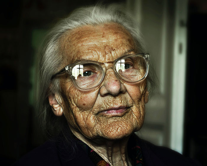 Elderly woman wearing glasses, reflecting wisdom and experience, illustrating advice from grandparents.