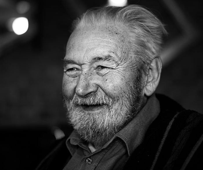 Elderly man smiling warmly, embodying wisdom and charm fitting advice from grandparents, captured in a candid moment.