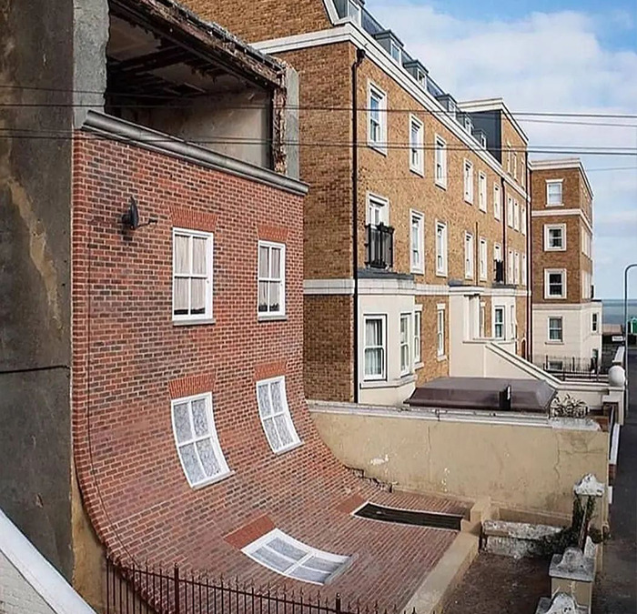 Cursed meme featuring a distorted building facade, creating an optical illusion on an Instagram page.