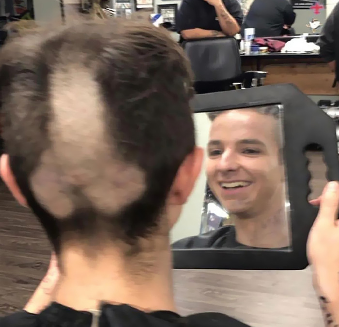 Cursed meme of a person with a unique haircut, reflected in a mirror in a barbershop setting.