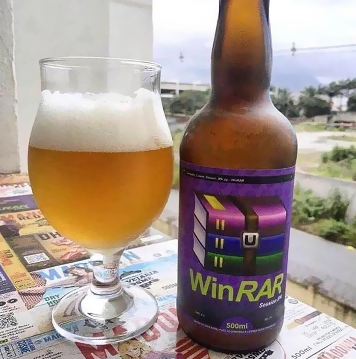 Cursed meme: A beer bottle labeled "WinRAR" next to a glass of beer on a table.
