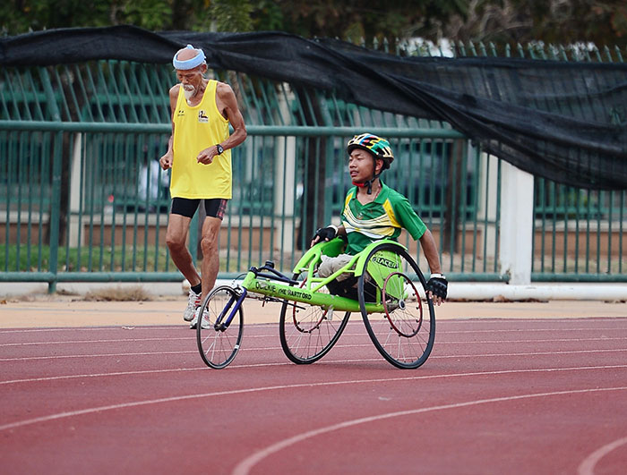 Old man running and boy riding near him