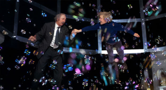 Charlie dancing between soap bubbles with a kid