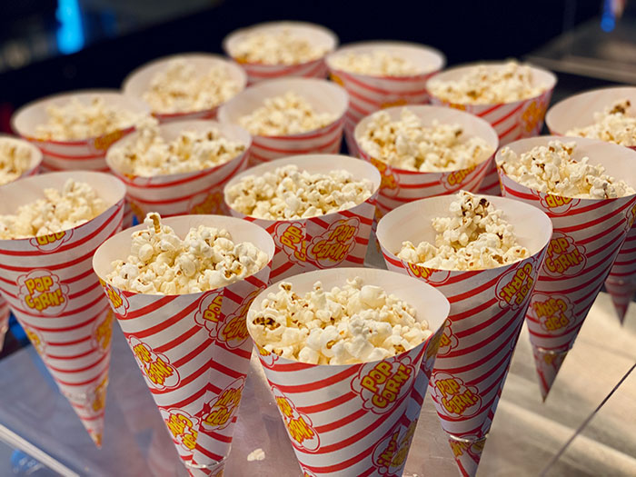 Numerous paper cones filled with popcorn, a popular food with a rich history.