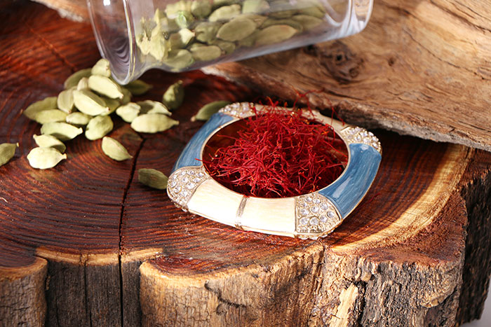 Saffron and green cardamom pods on a wooden surface, highlighting interesting food history facts.