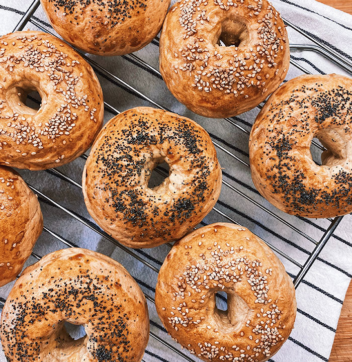 Freshly baked bagels with poppy and sesame seeds, representing a food history fact.