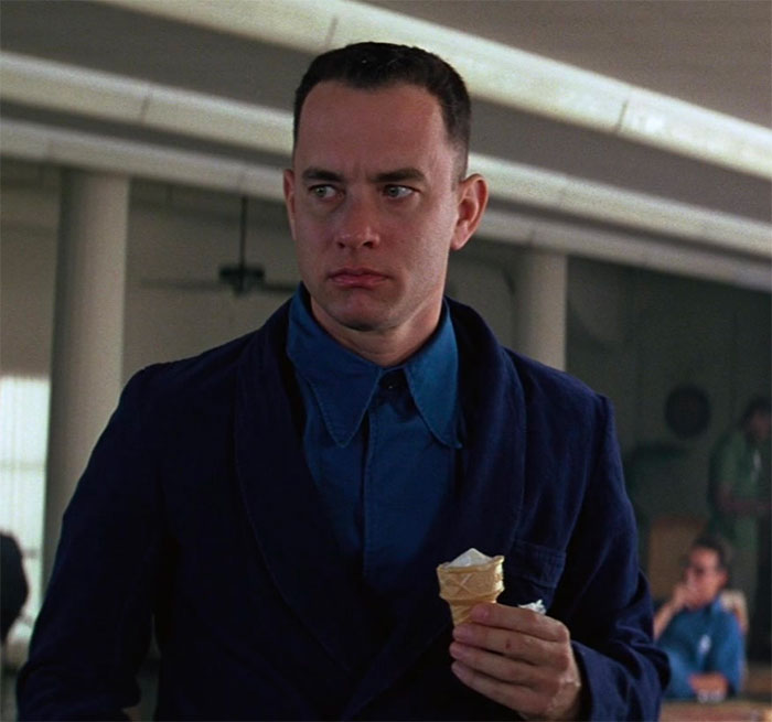 Forrest Gump holding an ice cream cone indoors, representing memorable Forrest Gump quotes from the iconic film.