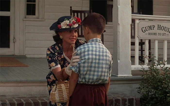 Mrs Gump talking with young Forrest Gump on the porch near Gump House, capturing emotional Forrest Gump quotes moment.