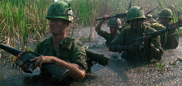 Forrest Gump in military training, carrying a rifle through water, representing key Forrest Gump quotes and scenes.