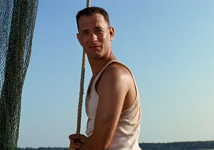Forrest Gump sailing on a boat in a sleeveless shirt, capturing iconic Forrest Gump quotes moment on the water.