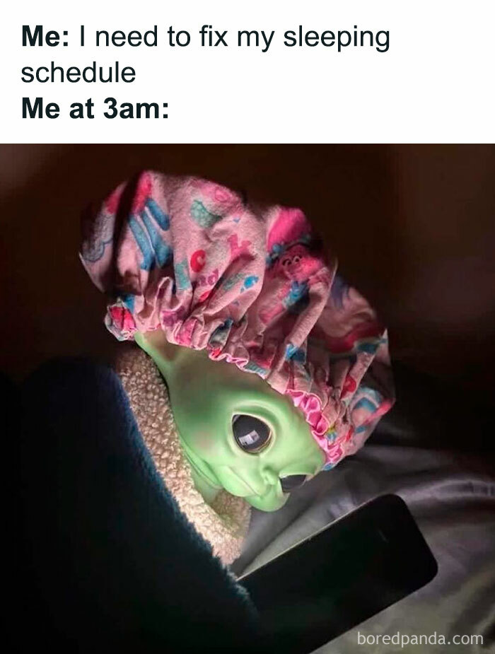 Alien in pink shower cap humorously stares at phone, embodying hilarious memes vibe.