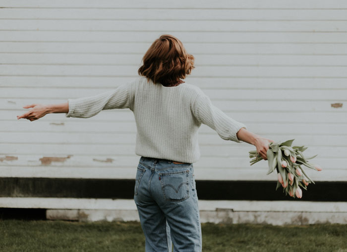 Happy woman standing with bouquet of tulips 