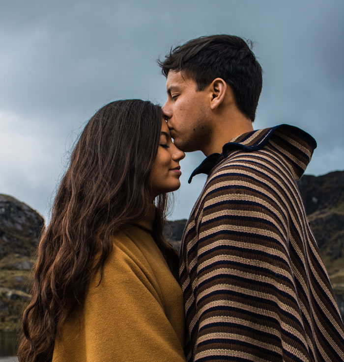 Man kissing a woman on forehead 