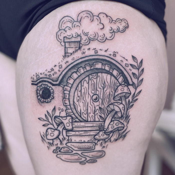 Tattoo of a Hobbit house with mushrooms and plants, inspired by Lord of the Rings.